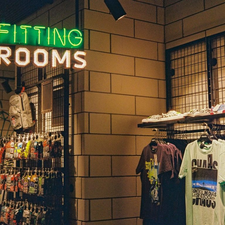 Modern Wear Display of clothing and shoes with a sign for fitting rooms above.